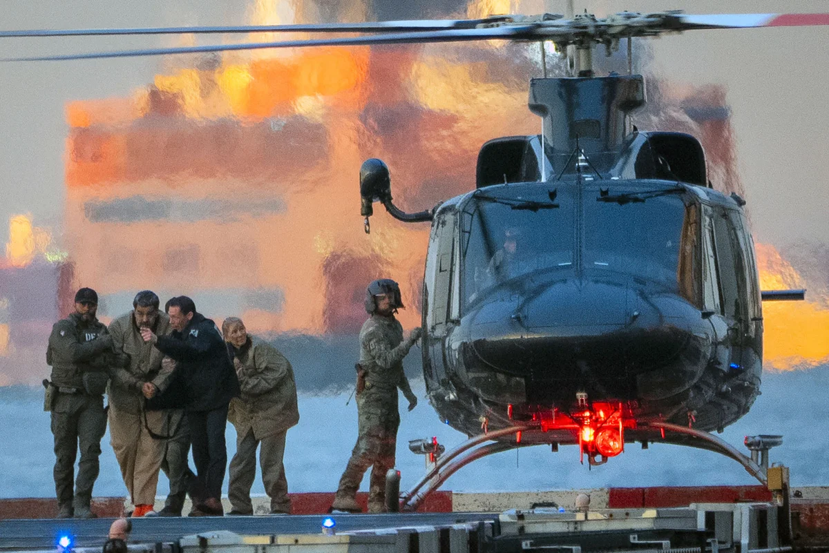 Nicolas Maduro, the ousted president of Venezuela, and his wife, Cilia Flores, are  escorted off a helicopter en route to the federal courthouse in Manhattan on Monday morning, Jan. 5, 2026. 